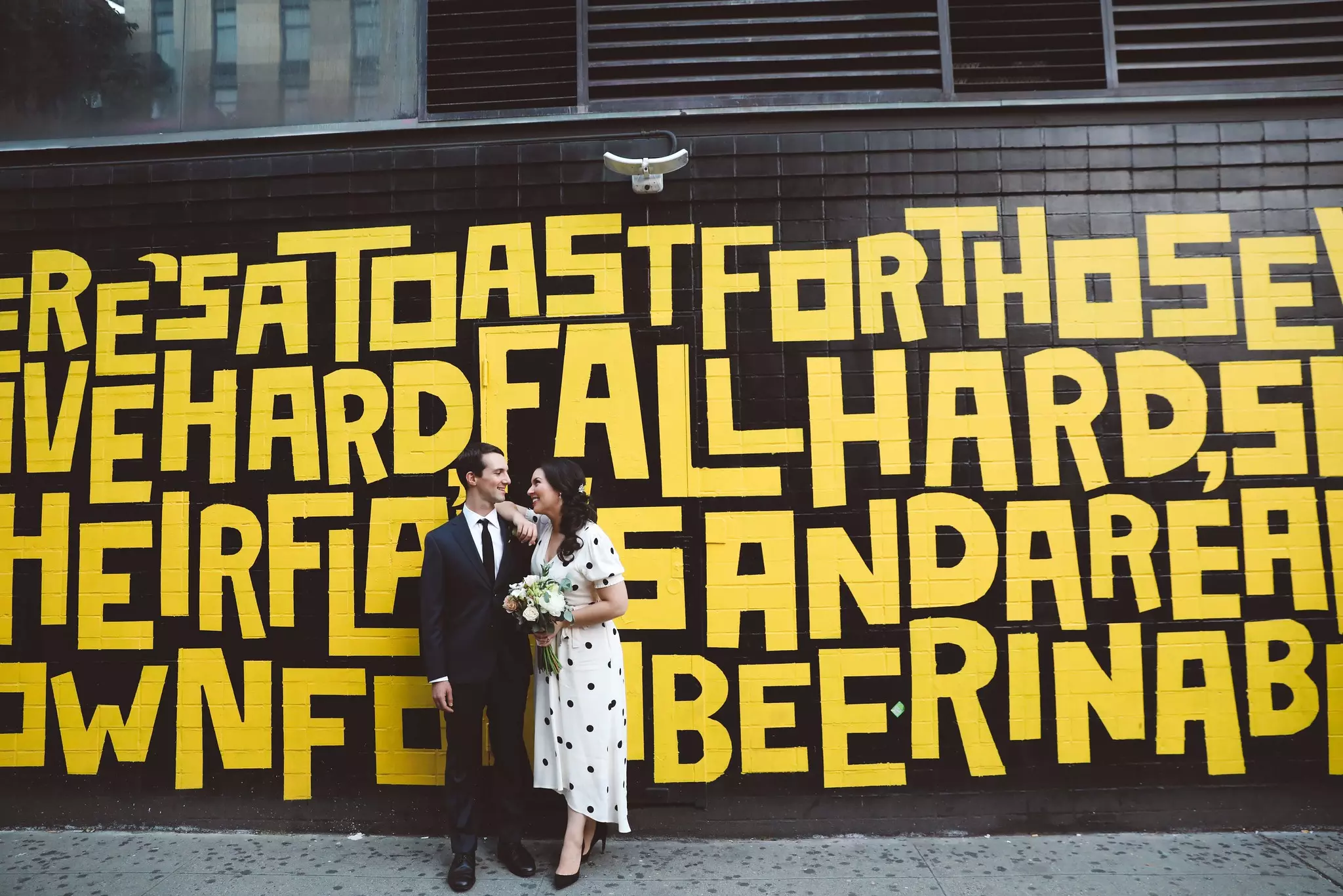 Wedding couple standing under a sign that says Robinson