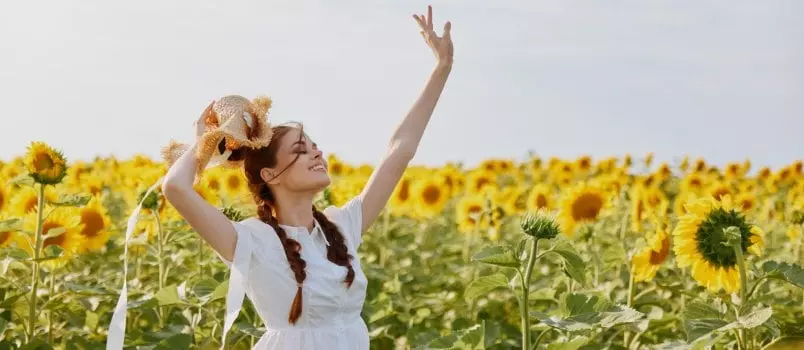 Woman with pigtails looking in the sunflower field