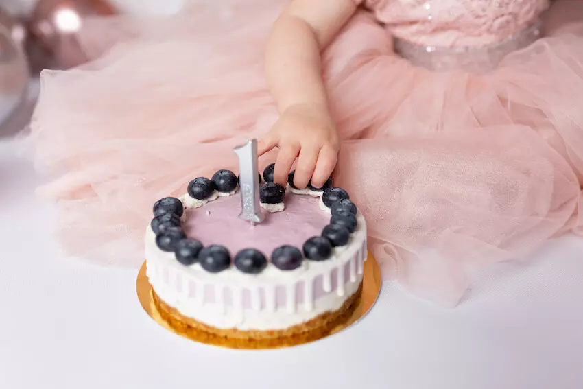 Berry first birthday: baby getting berries from her cake