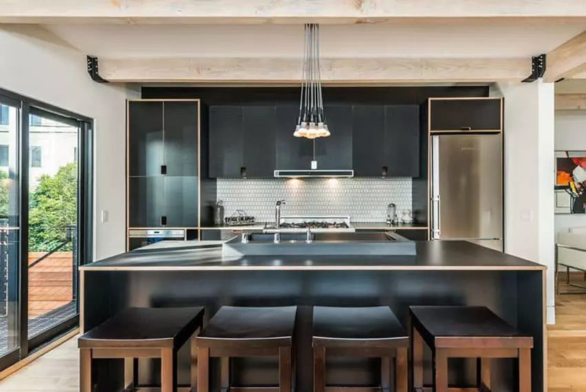 Small contemporary kitchen with Calacatta Carrara marble counter, dark cabinets, and Edison lights