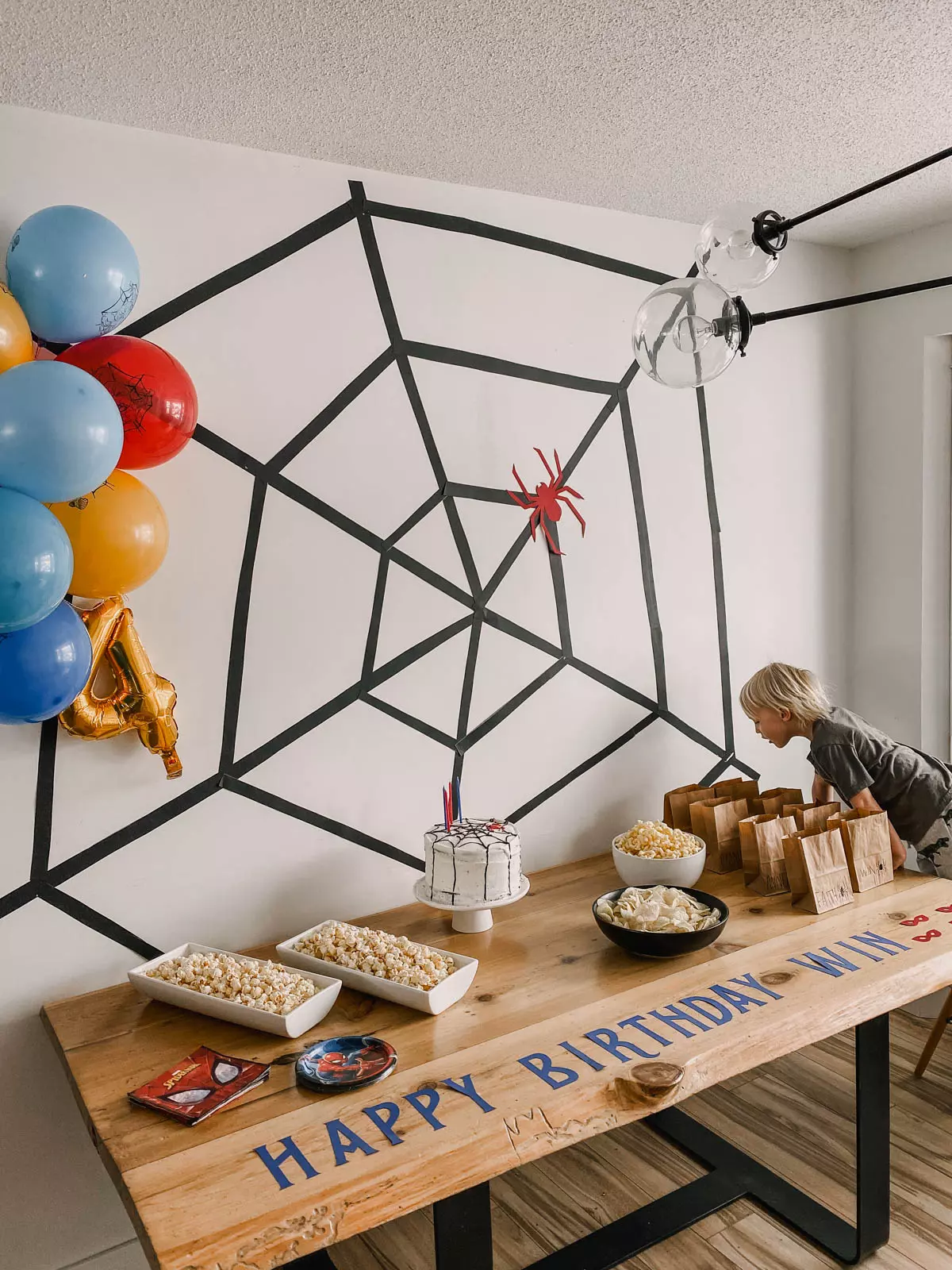 DIY Spiderman backdrop using cardstock paper spider and black poster board spiderweb