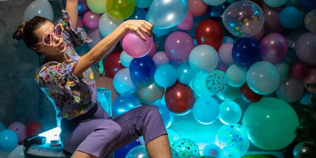 Woman posing for a photo in a balloon-filled photo booth