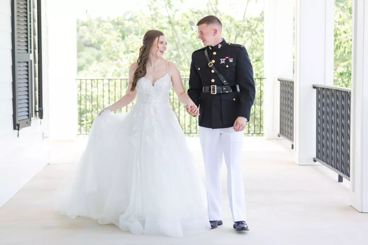 groom in military uniform with bride on wraparound porch at Kendall Point